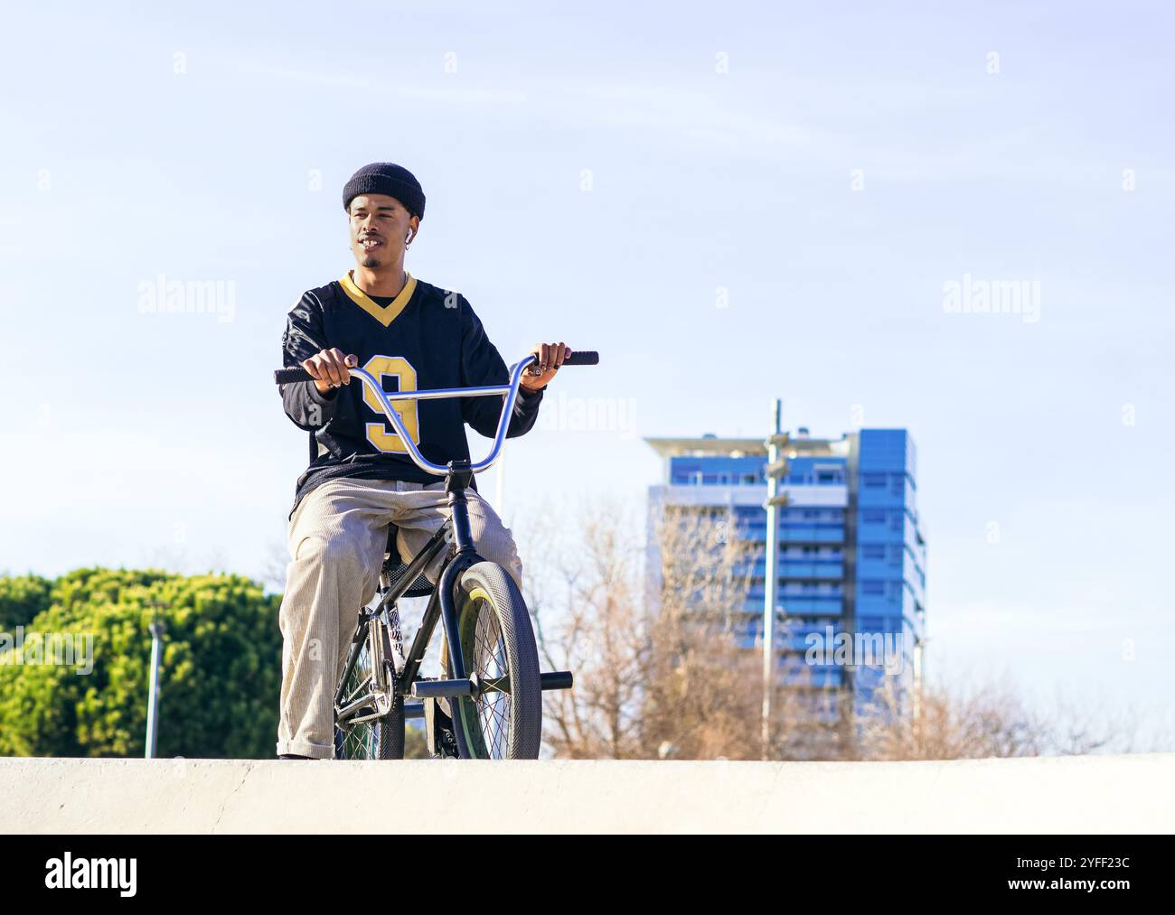 Portrait d'un jeune homme afro-américain avec un vélo d'essai dans un skatepark dans une ville Banque D'Images