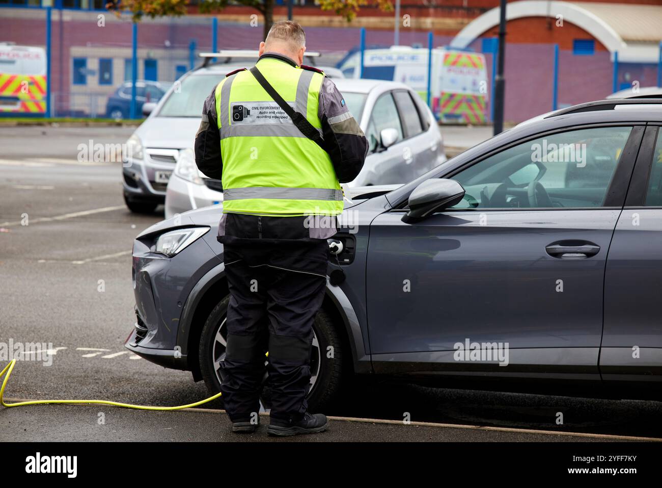 Une voiture électrique reçoit un ticket de parking au Wythenshawe Forum Banque D'Images