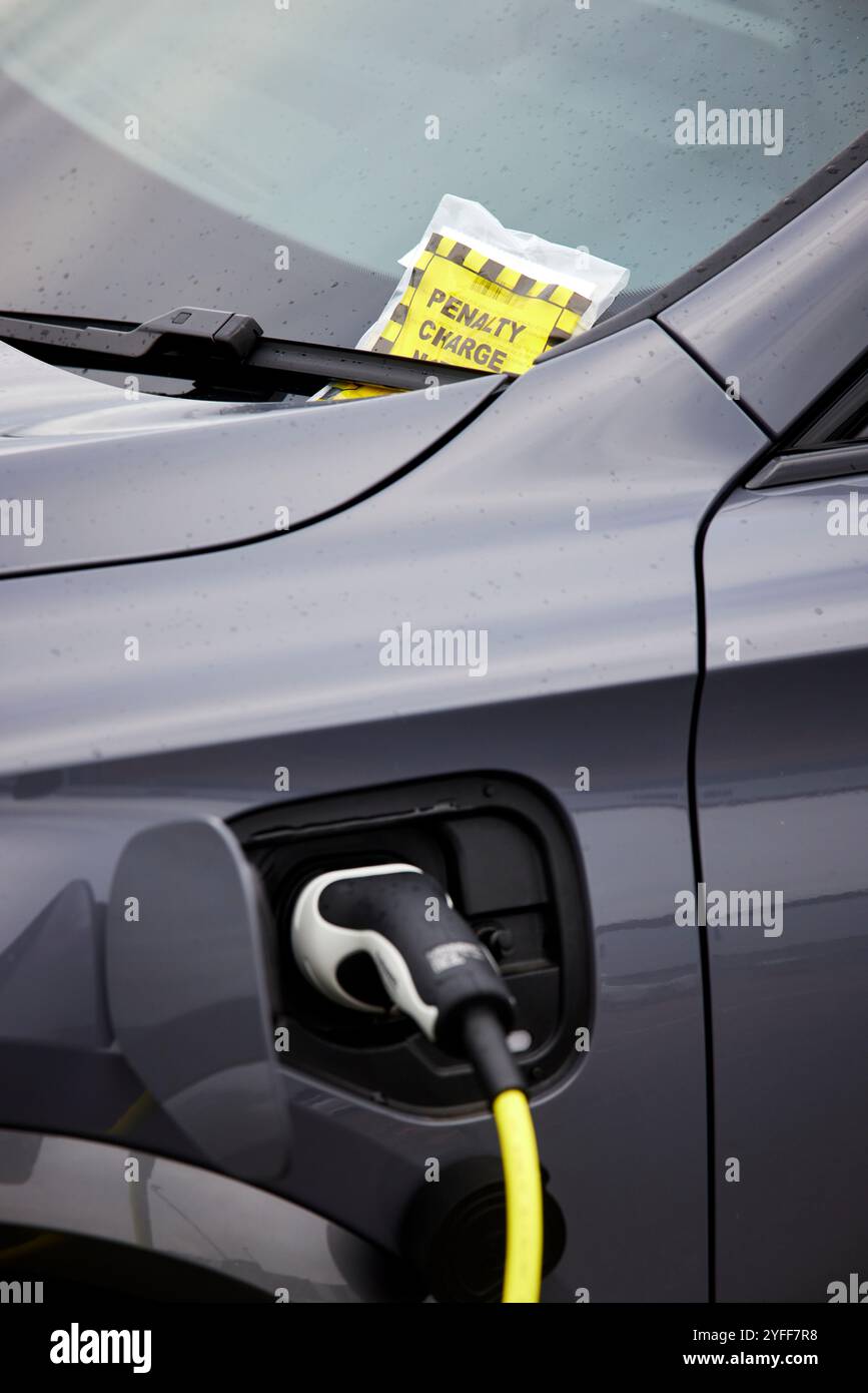 Une voiture électrique reçoit un ticket de parking au Wythenshawe Forum Banque D'Images