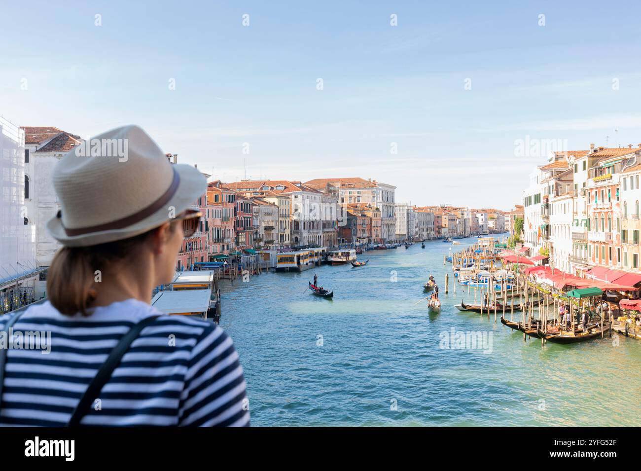 Jeune femme touriste voyageant dans la ville de Venise, Italie, regardant du pont du Rialto à Venise, Italie. Banque D'Images