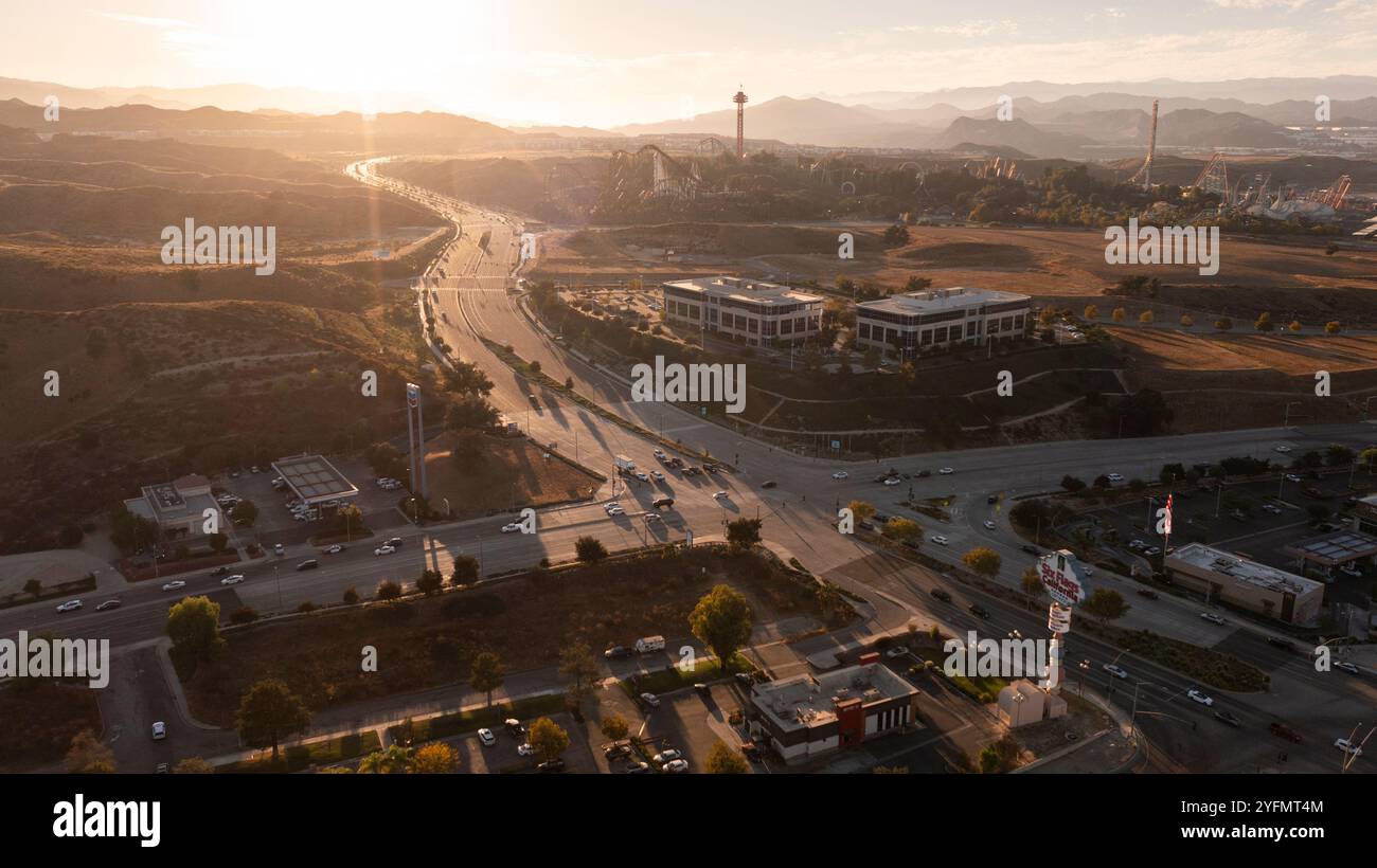 Santa Clarita, Californie, États-Unis - 24 octobre 2024 : le soleil se couche sur le centre-ville de Santa Clarita et le parc d'attractions six Flags. Banque D'Images