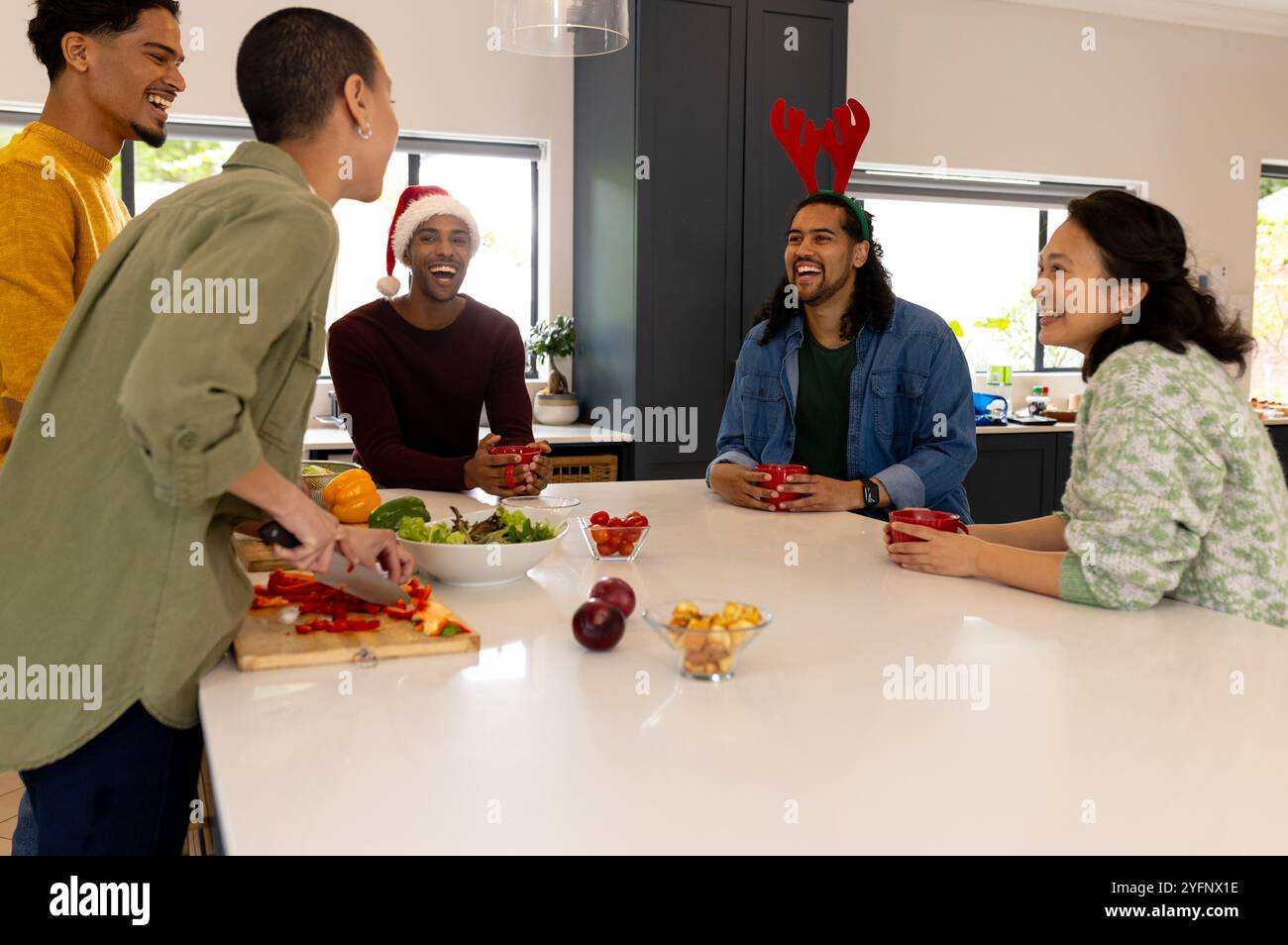 Temps de Noël, amis multiraciaux rires et préparer le repas de vacances ensemble à la maison Banque D'Images