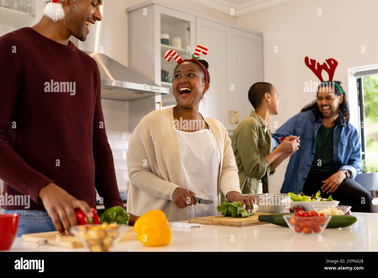Temps de Noël, amis multiraciaux rires et préparer le repas de vacances ensemble à la maison Banque D'Images