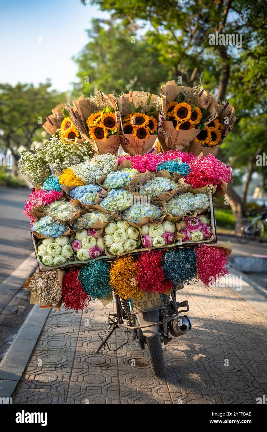 Bouquets emballés cadeau de lotus (Nelumbo nucifera), hortensia (Hydrangeaceae), tournesols (Helianthus) et autres fleurs à vendre sur une moto à Han Banque D'Images