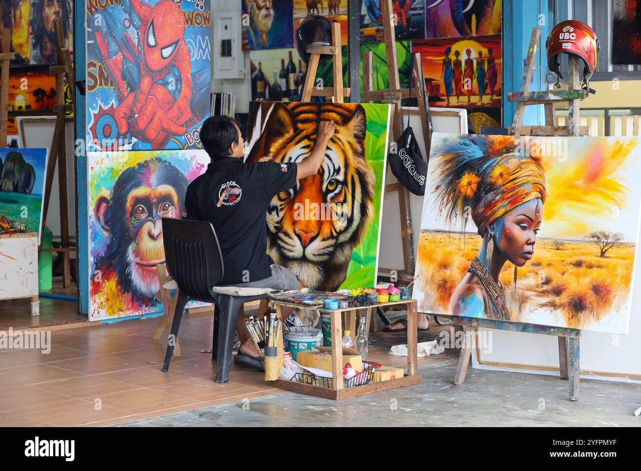 Artiste assis avec des peintures sur la rue de la ville de Khao Lak en Thaïlande Banque D'Images
