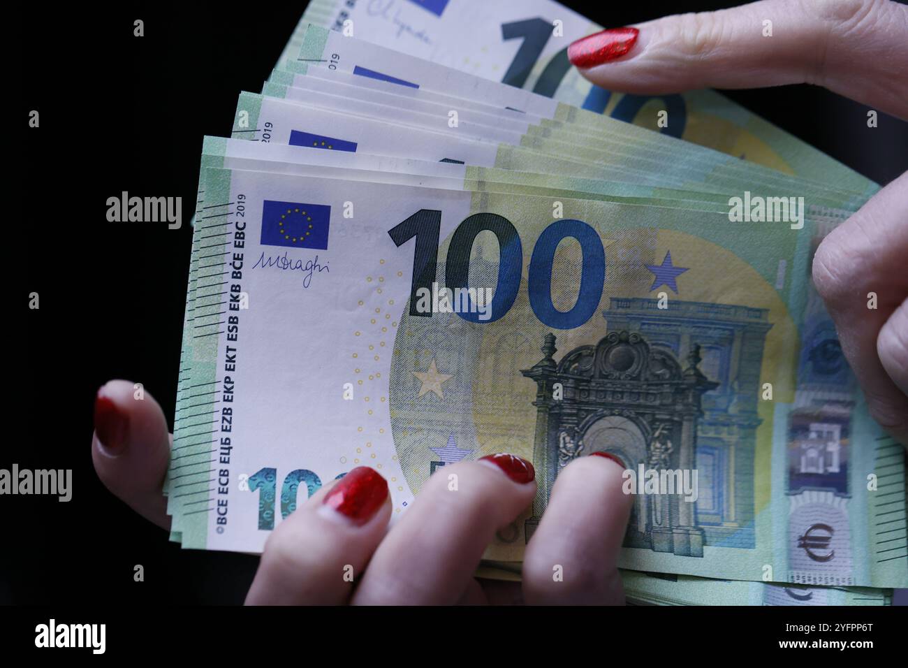 Femme détenant et comptant 100 billets de banque en euros paiement d'assurance patrimoine ou épargne à vie. Banque D'Images