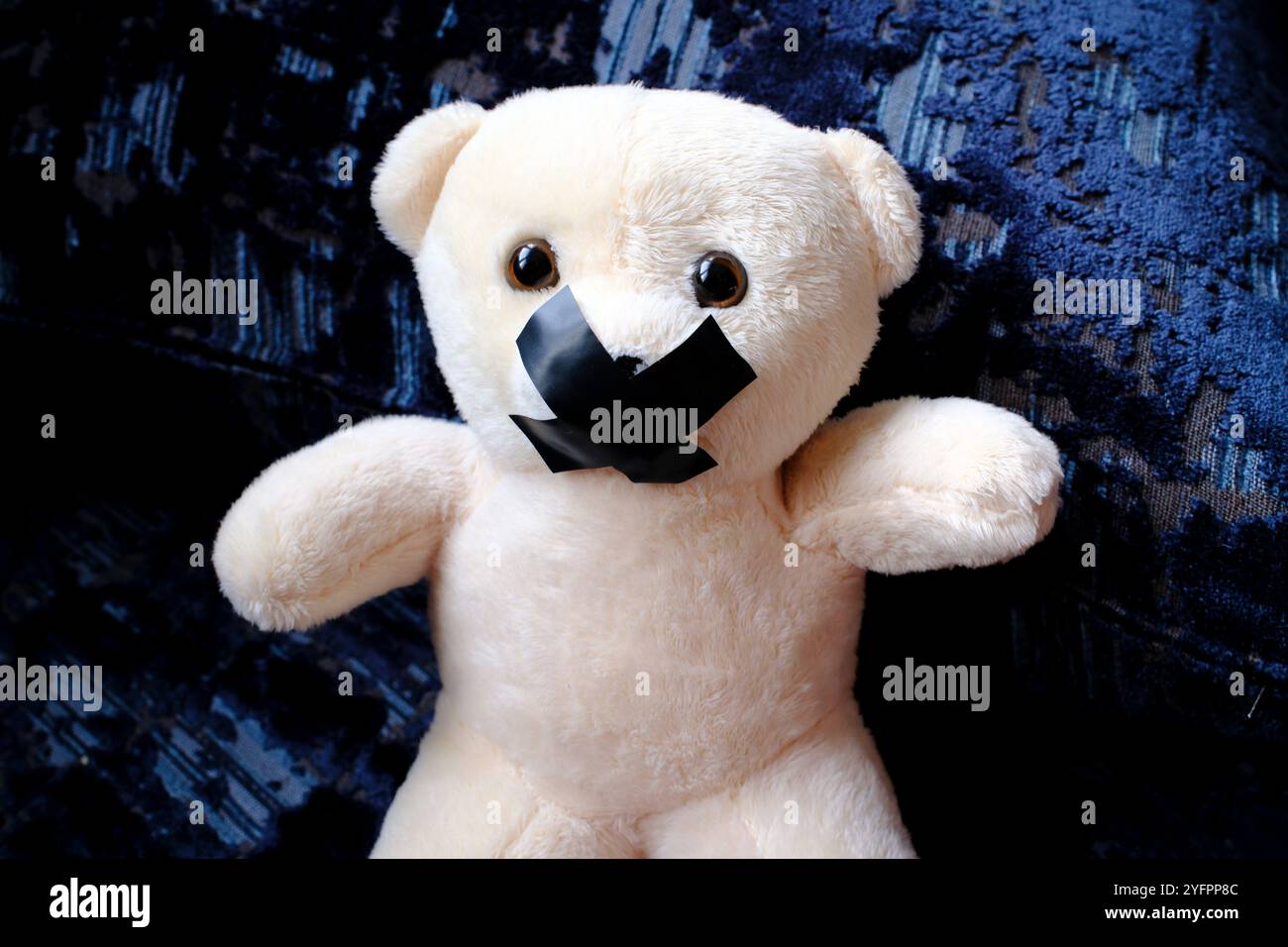 Ours en peluche avec du ruban adhésif sur sa bouche. Symbole du silence pendant la maltraitance des enfants Banque D'Images