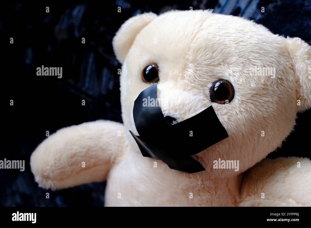Ours en peluche avec du ruban adhésif sur sa bouche. Symbole du silence pendant la maltraitance des enfants Banque D'Images