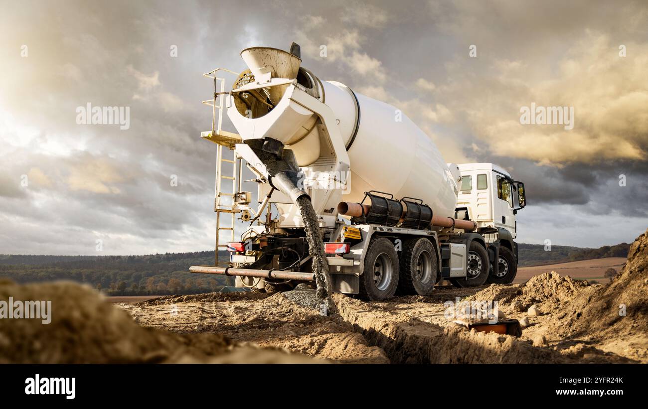 Camion mélangeur de béton coulant du béton sur un chantier de construction Banque D'Images