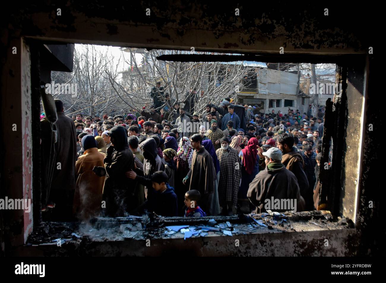 Le peuple cachemirien évalue la maison d'habitation endommagée dans le village de Kanigam, district de Shopian, au sud de Srinagar, au Cachemire sous administration indienne, le 26 décembre 2020. Deux millitants cachemiriens locaux ont été tués et deux soldats paramilitaires indiens ont été blessés au cours d'un affrontement de nuit. Banque D'Images