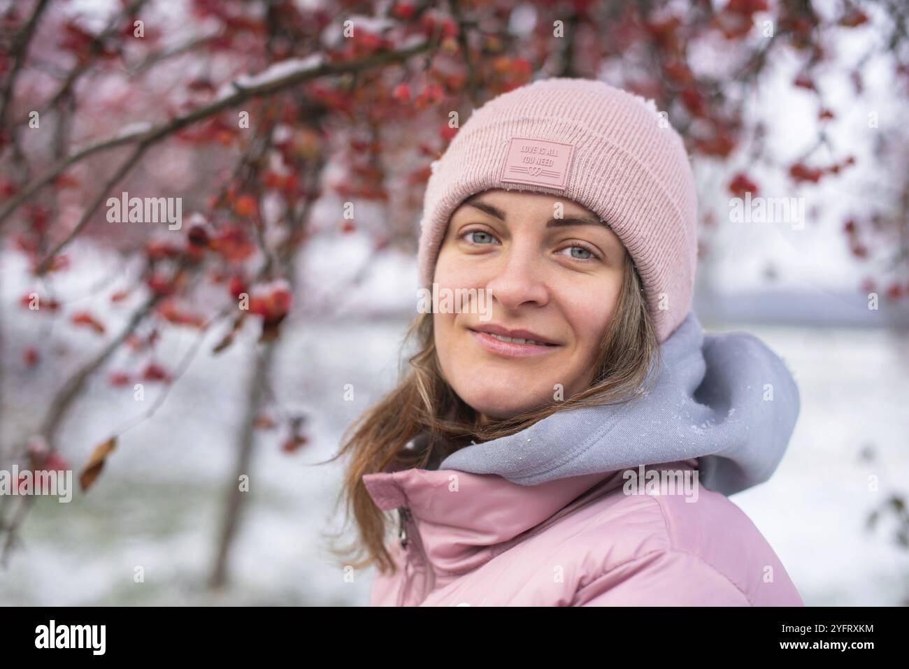 Portrait de style de vie d'hiver de jolie fille joyeuse. Sourire et s'amuser dans le snowpark. Des flocons de neige tombent Banque D'Images