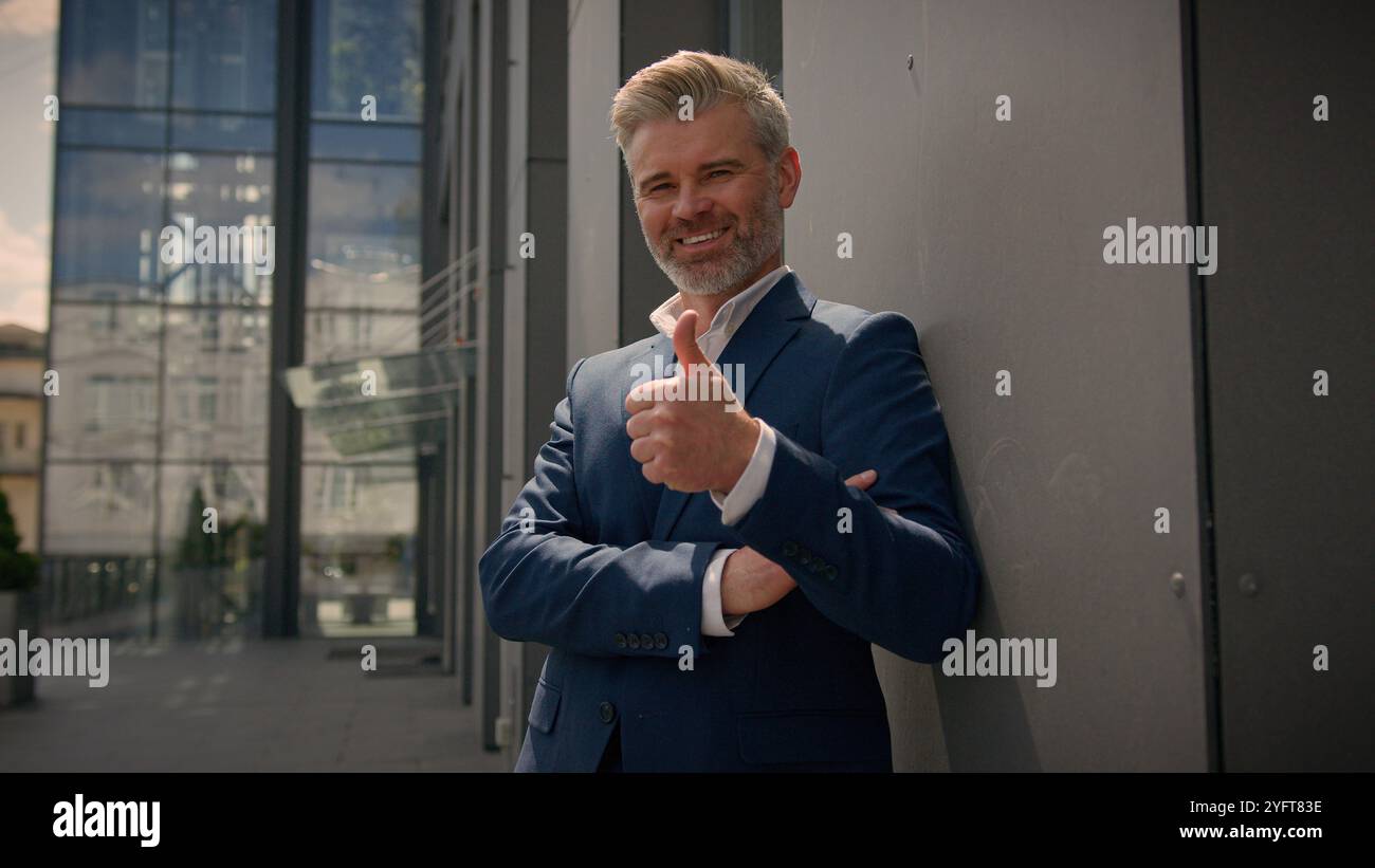Souriant vieil homme caucasien senior mature retraité homme d'affaires homme d'affaires d'âge moyen entrepreneur d'affaires bon heureux d'accord recommander de montrer le pouce Banque D'Images