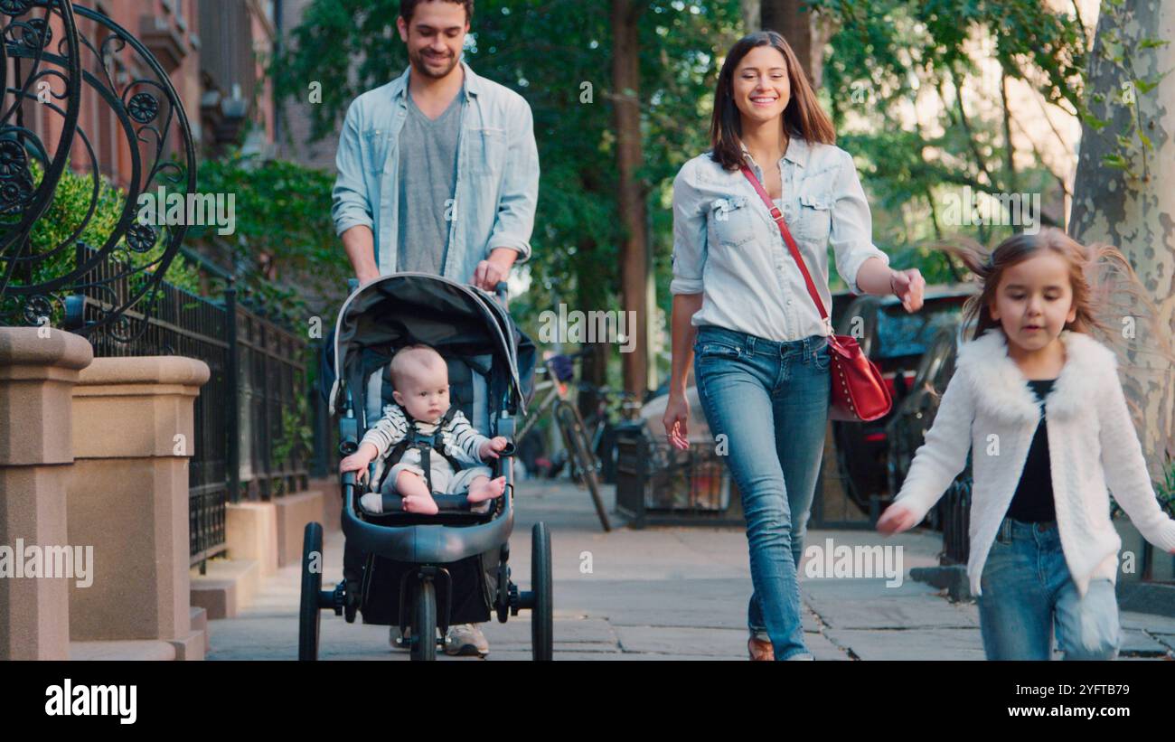 Journée en famille avec papa poussant bébé dans Buggy alors qu'ils marchent le long de Urban Street à New York City USA Banque D'Images