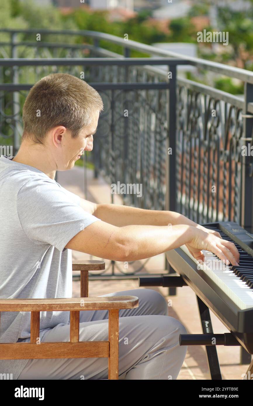 Un homme aime jouer d'un instrument de musique à clavier. Portrait d'un pianiste pris lors de sa performance. Jouer d'un piano électronique. Banque D'Images