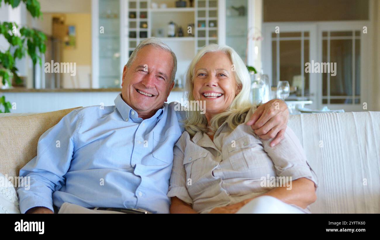 Portrait de couple senior aimant assis avec sur le canapé à la maison ensemble Banque D'Images