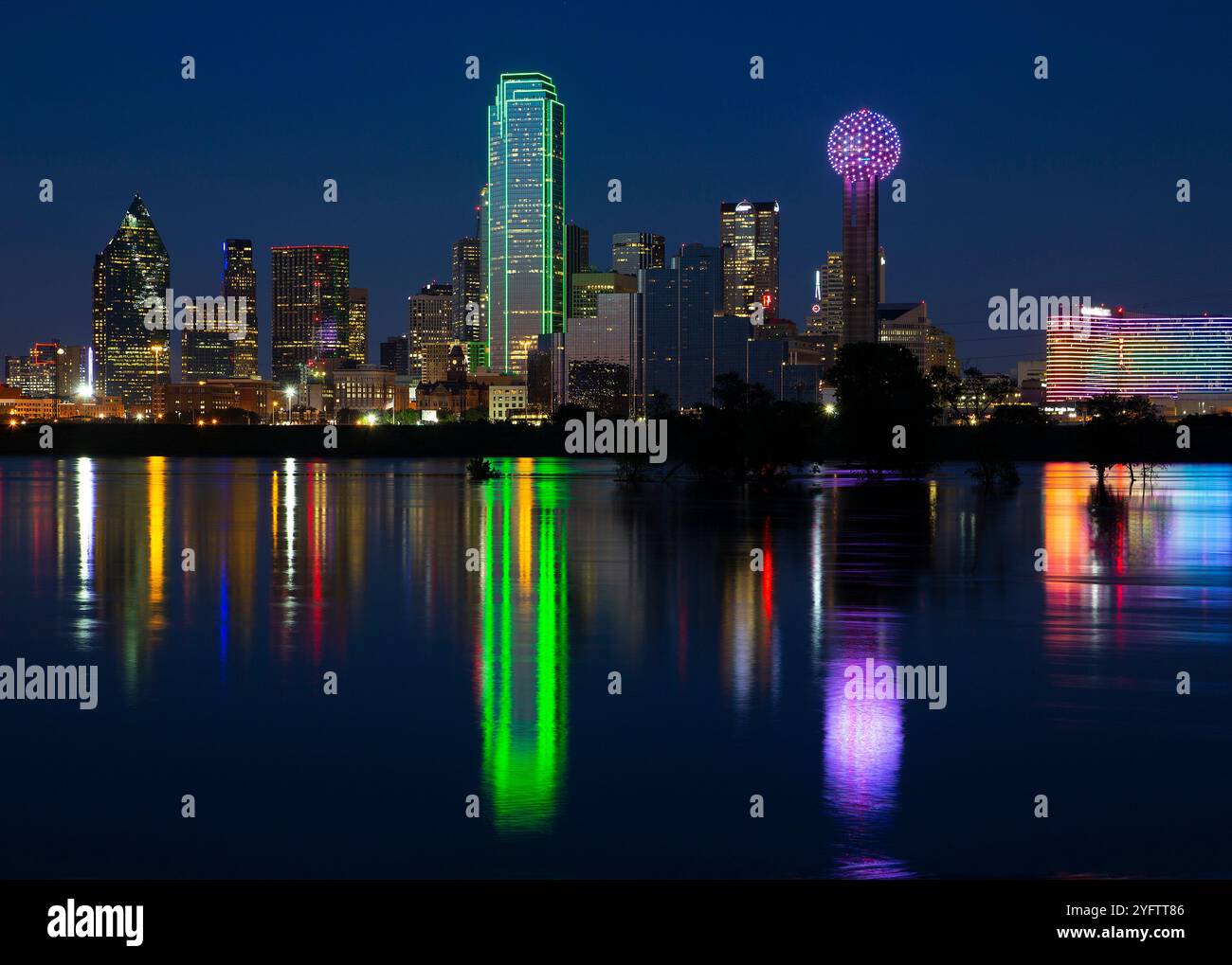 Belle vue sur les lumières néons lumineuses du centre-ville de Dallas Skyline reflétant les eaux inondées de la rivière Trinitiy Levee Banque D'Images