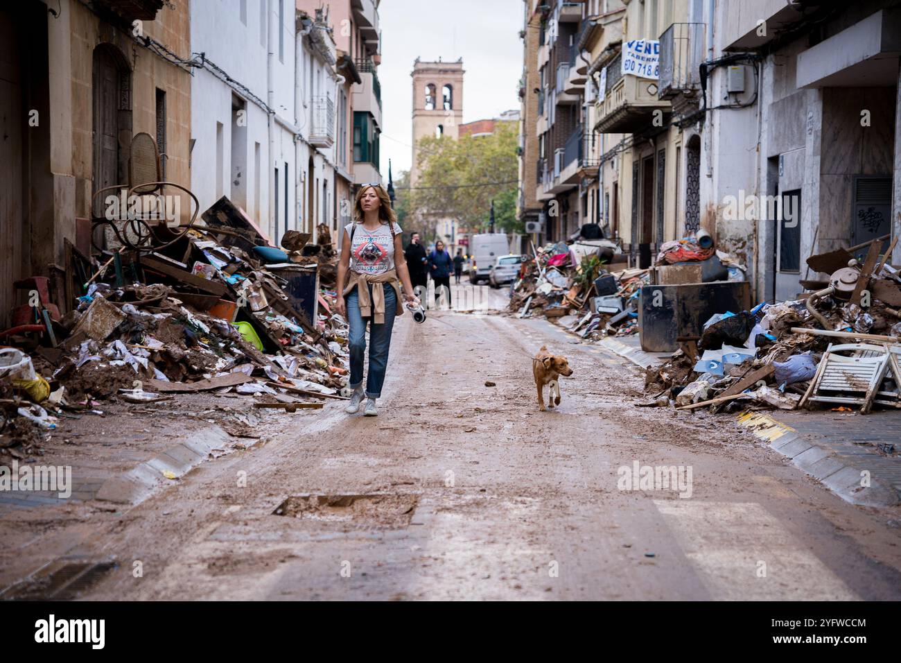 Valencia, Espagne. 4 novembre 2024. Une femme est vue marcher avec son chien parmi les décombres dans le centre-ville. Plus de 200 personnes ont été tuées dans les crues soudaines qui ont touché la région autour de Valence, en particulier les villes de Paiporta, SedavÃ¬ et Benatusser, dans ce qui est considéré comme la pire catastrophe naturelle de l'histoire de l'Espagne et l'une des pires de l'histoire de l'Europe. Les inondations ont été causées par un phénomène atmosphérique connu sous le nom de Dana. Avec de nombreux corps encore sous les décombres, le nombre de victimes devrait augmenter. (Crédit image : © Davide Bonaldo/SOPA images via ZUMA Press Wire) USAGE ÉDITORIAL O Banque D'Images
