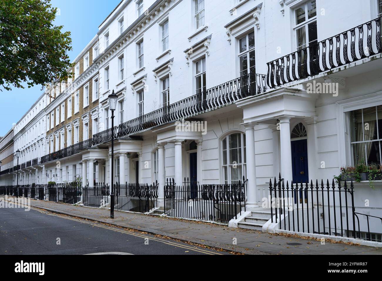 Longue rangée de maisons de ville en stuc blanc typiques des quartiers résidentiels du centre de Londres Banque D'Images