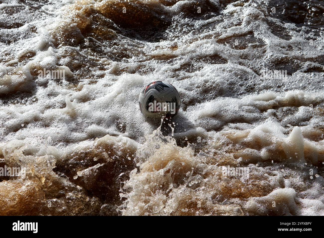 football capturé dans le courant de foucault tourbillonnant dans les eaux tourbées de la rivière crana buncrana, comté de donegal, république d'irlande Banque D'Images