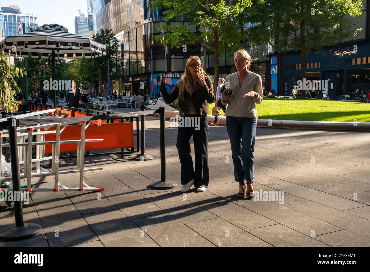 Les employés de bureau apprécient le temps exceptionnellement chaud en faisant une pause au Manhattan West Complex à New York le mercredi 23 octobre 2024 (© Richard B. Levine) Banque D'Images