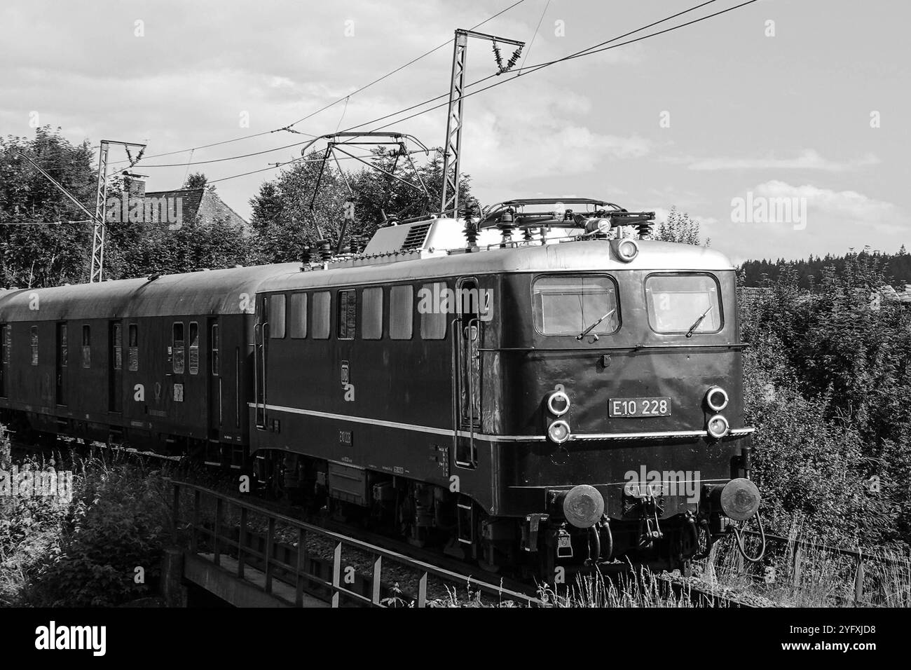 Hans Symbolbild E10 228, historische deutsche Elektrolokomotive, in klassischer Schwarz-Weiß-Fotografie, typisch für den Eisenbahnverkehr der Nachkriegszeit, Teil der Baureihe E10 der Deutschen Bundesbahn, fährt auf einer landschaftlich reizvollen Strecke, Oberleitungen und Schienen, nostalgischer 228 Banque D'Images