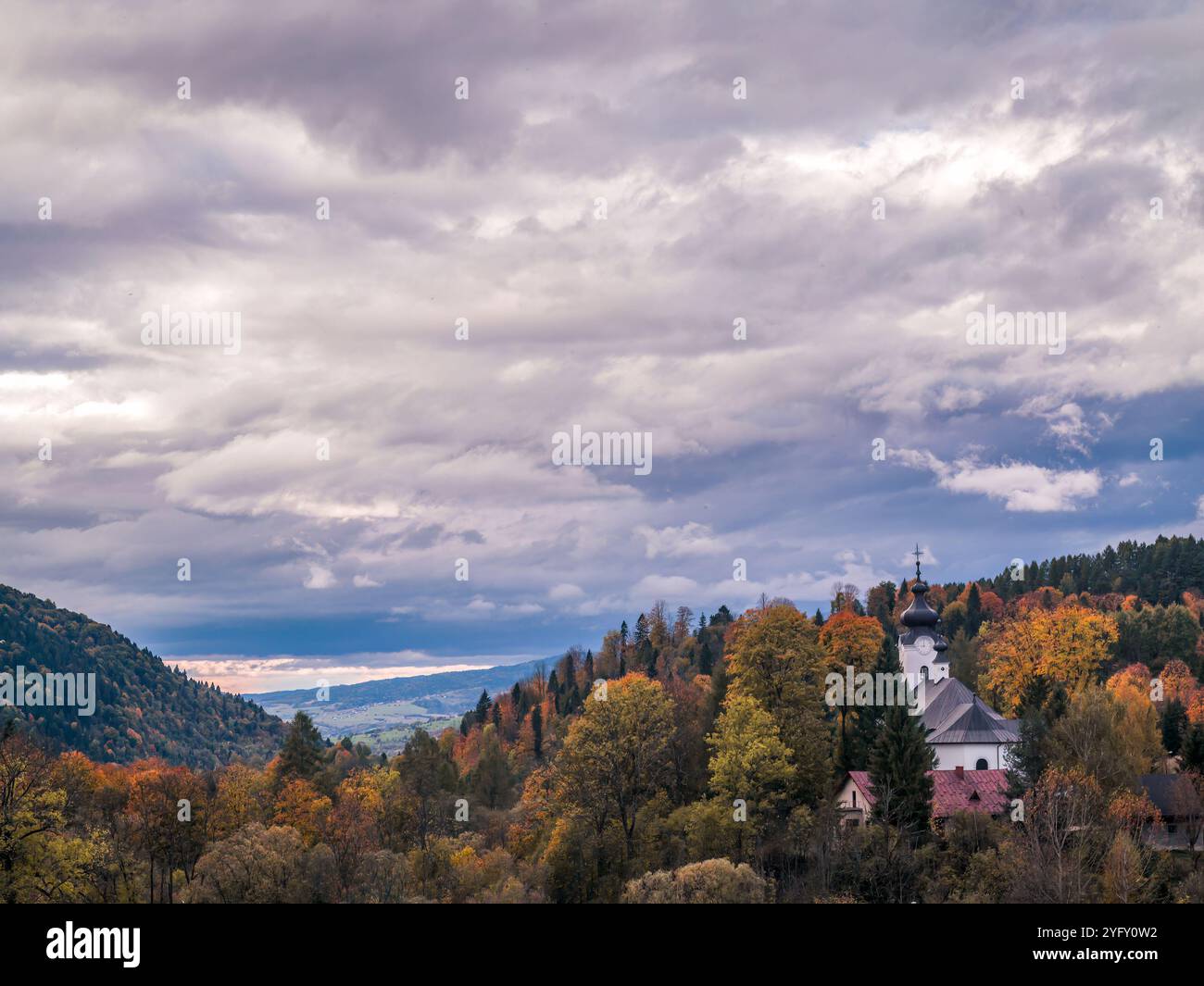 Une vue panoramique pittoresque sur les collines et les forêts vallonnées en automne. Le feuillage d'automne vibrant crée une atmosphère enchanteresse sous un ciel nuageux, hig Banque D'Images