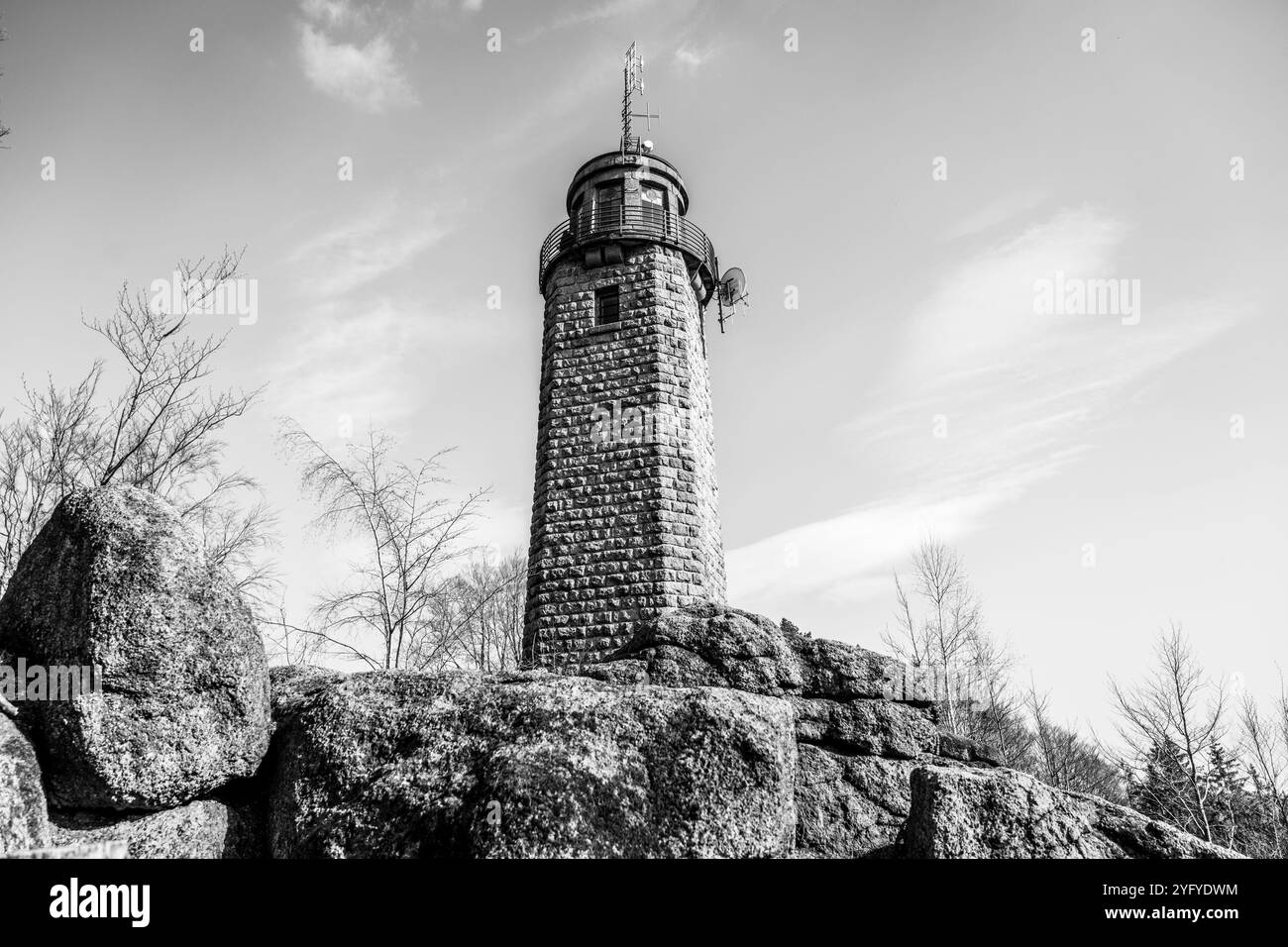 La tour d'observation de Prosec s'élève au-dessus d'un terrain rocheux, offrant une vue panoramique sur le paysage environnant près de Jablonec nad Nisou, en Tchéquie, sous un ciel clair. Photographie noir et blanc Banque D'Images
