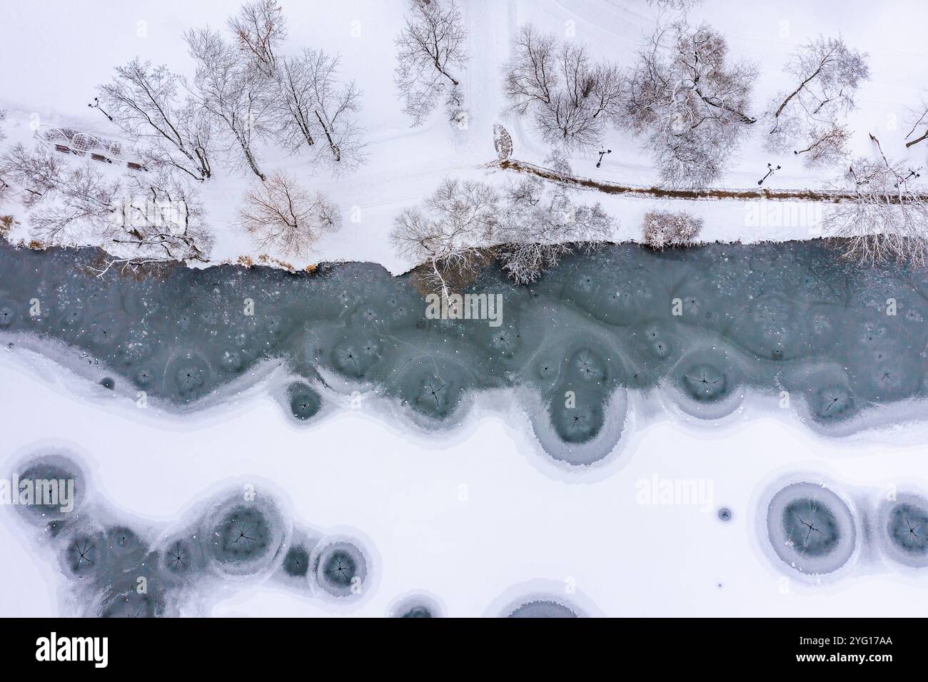 paysage de parc d'hiver avec rive enneigée et rivière glacée. vue aérienne par drone. Banque D'Images