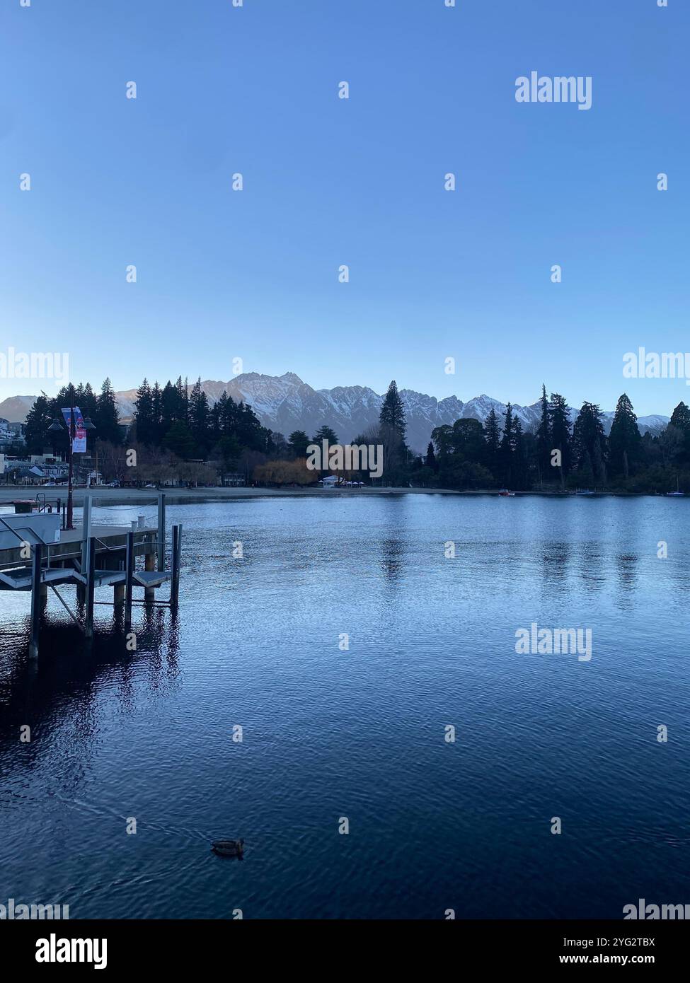 Paysage de montagnes et d'arbres à Queenstown derrière le lac Wakatipu pendant l'hiver en Nouvelle-Zélande, Île du Sud. - Image de stock capturée avec un smartphone