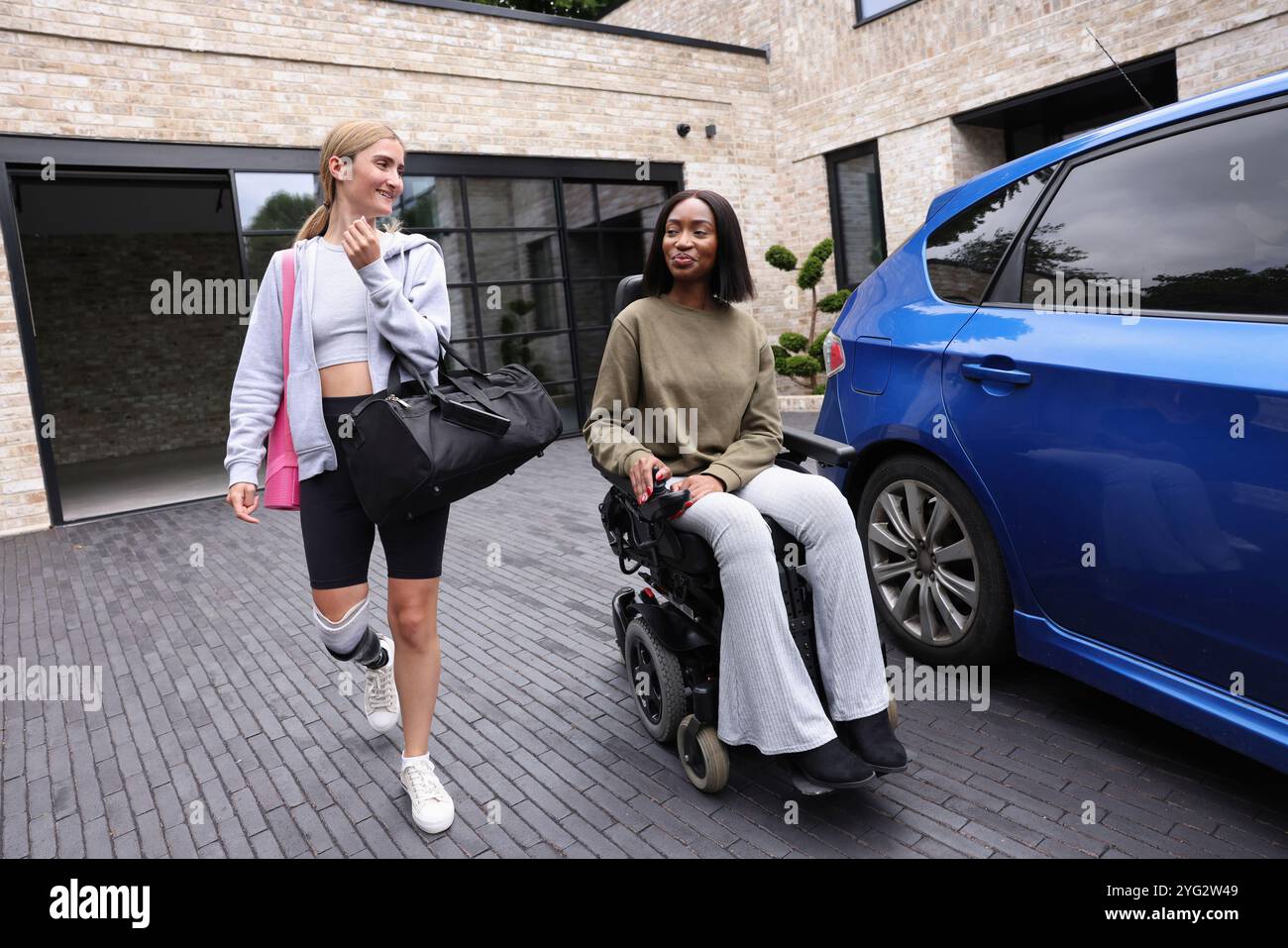 Des femmes souriantes quittant le bâtiment de gymnastique ensemble Banque D'Images