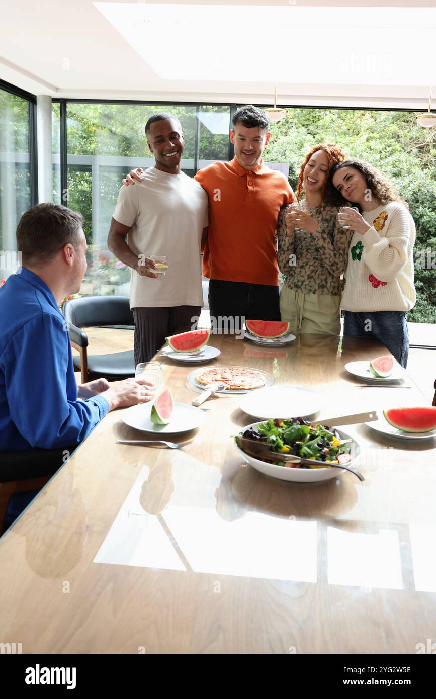 Amis souriants à table Banque D'Images Amis souriants à table Banque D'Images
