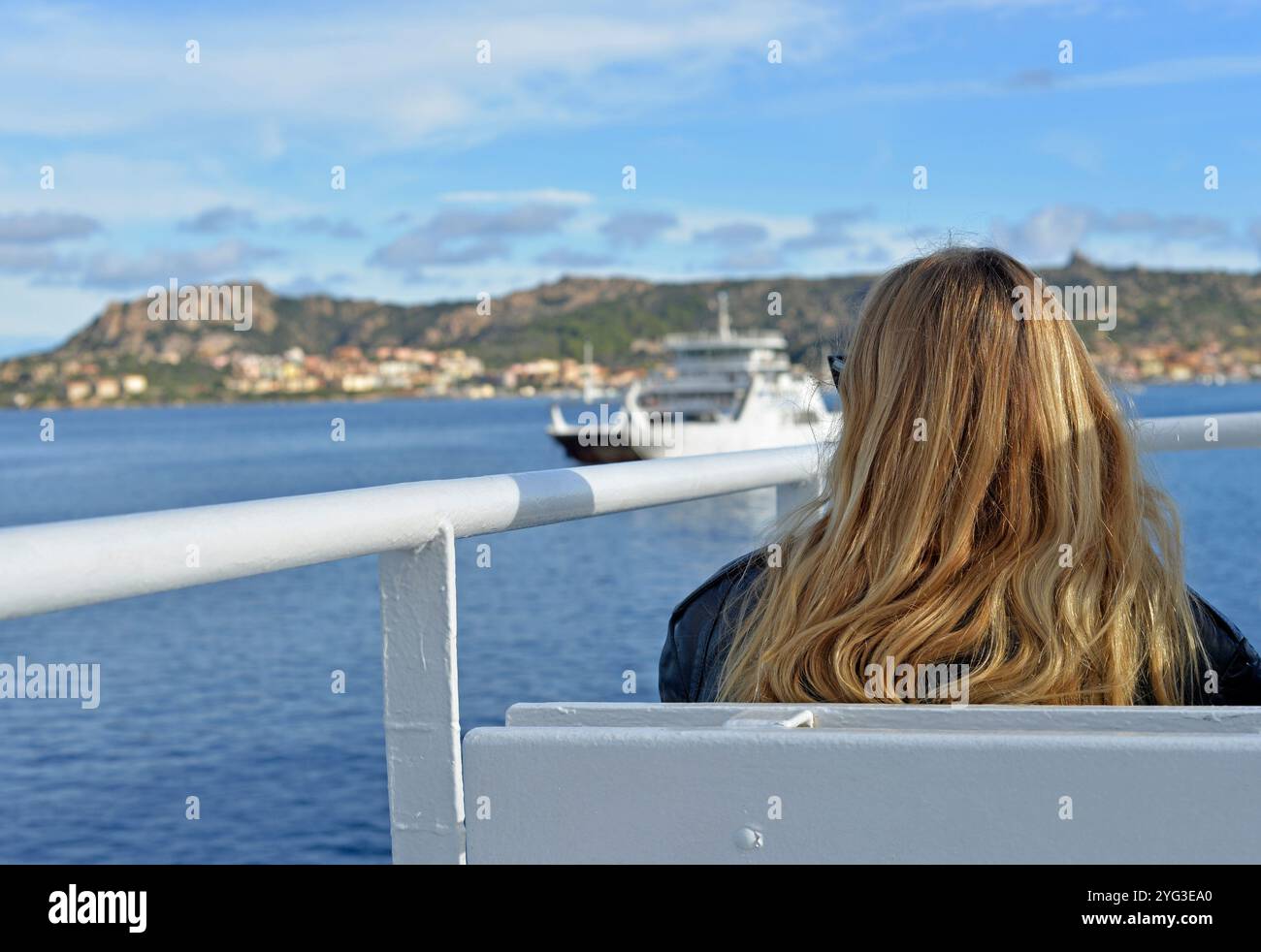 Passager féminin assis sur le pont extérieur d'un ferry naviguant vers l'île de Maddalena depuis Palau, Sardaigne, Italie Banque D'Images