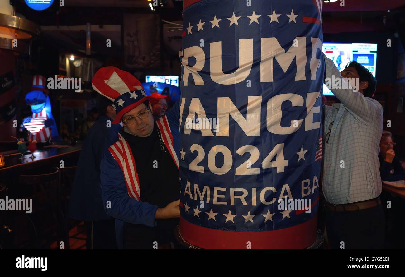 JÉRUSALEM - 6 NOVEMBRE : les partisans du candidat républicain à la présidence, l’ancien président Donald Trump, accrochent un drapeau de campagne Trump-Vance alors qu’ils assistent à une fête de veille électorale dans le bar Mike’s place le 6 novembre 2024 à Jérusalem. Les Américains ont voté aujourd’hui dans la course présidentielle entre le candidat républicain, l’ancien président Donald Trump, et le candidat démocrate, le vice-président Kamala Harris, ainsi que lors de multiples élections étatiques qui détermineront l’équilibre des pouvoirs au Congrès. Banque D'Images