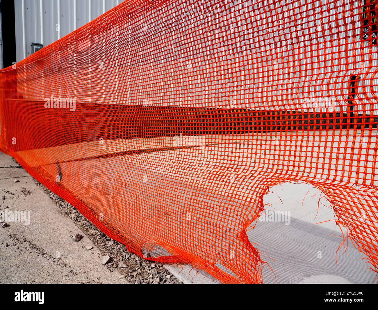 Barrière de construction en plastique orange déchiré Banque D'Images