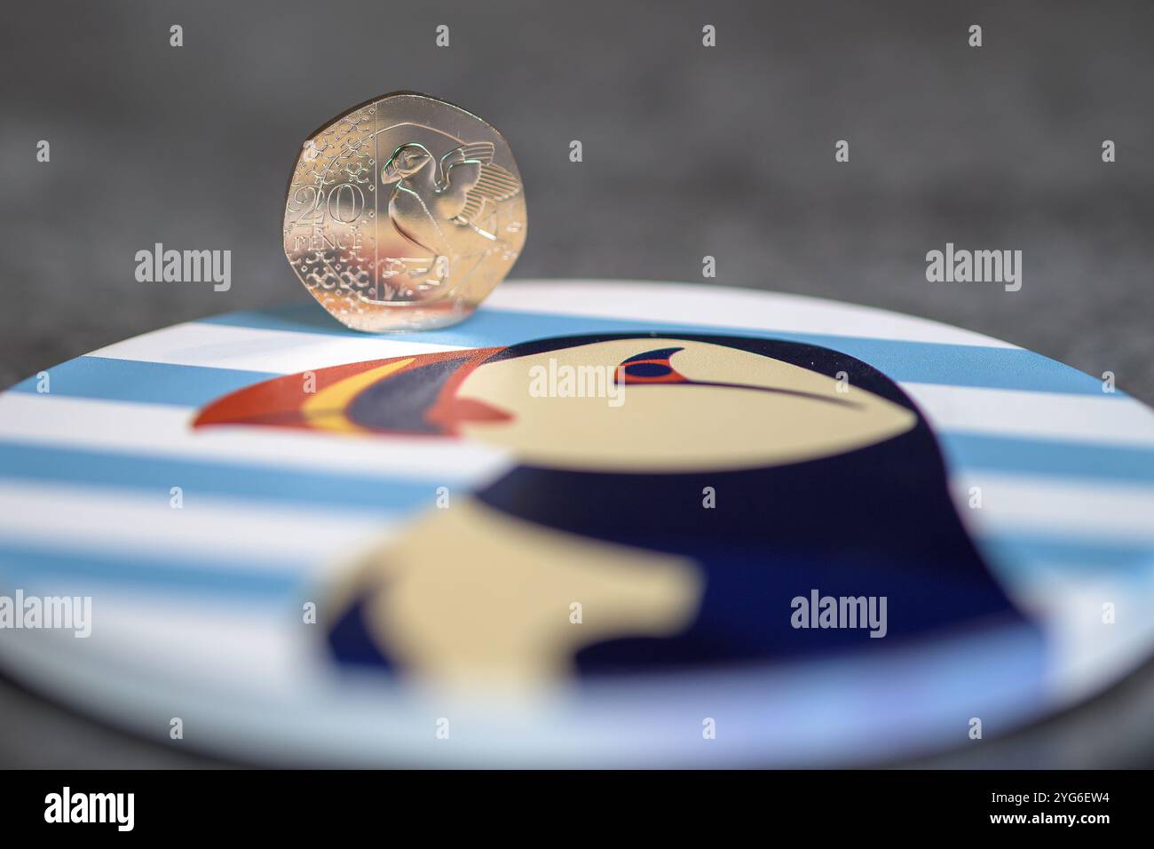 Une pièce de 20 pence avec un macareux assis sur un dessous de verre bleu et blanc dépouillé avec un macareux dessus Banque D'Images