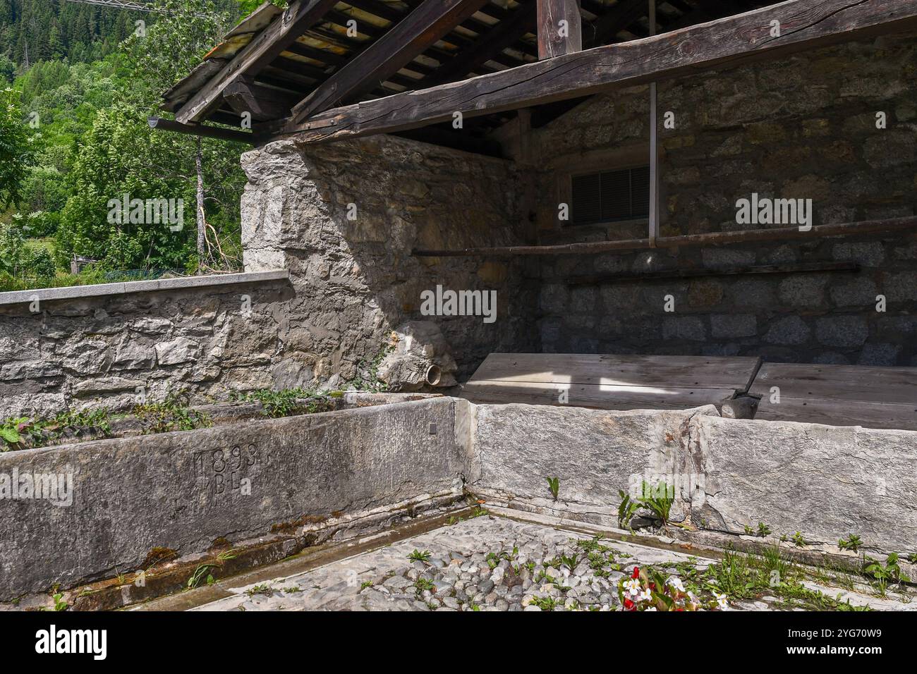 Ancien lavoir en pierre avec date gravée de 1893 dans le village alpin de Dolonne, à une courte distance du centre de Courmayeur, Aoste, Italie Banque D'Images