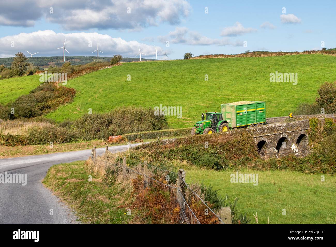 John Deere Tractor transporte du maïs fraîchement tiré dans la cour du fermier à Bauravilla, West Cork, Irlande. Banque D'Images