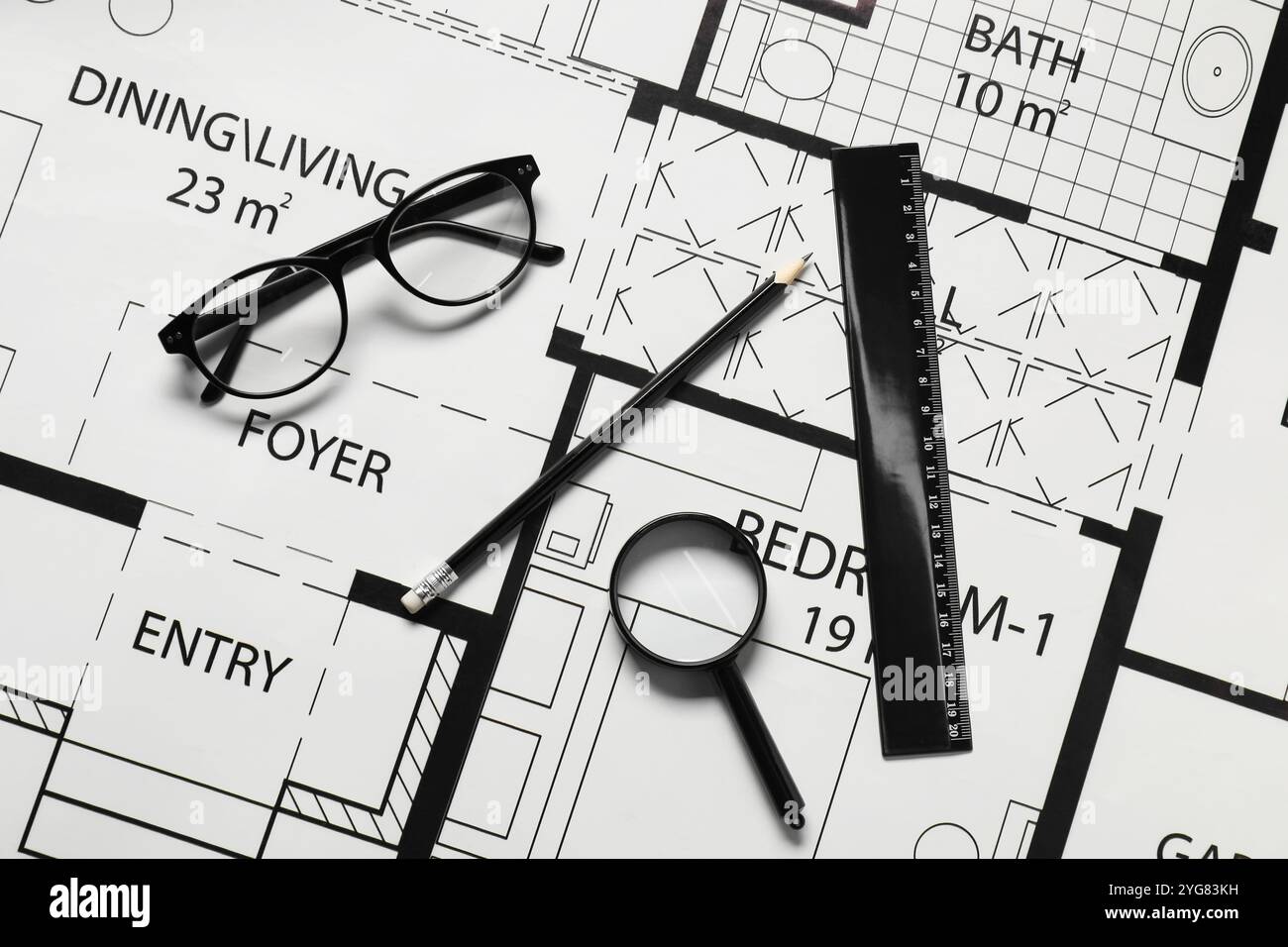 Règle, lunettes, loupe et crayon sur différents dessins architecturaux, vue de dessus Banque D'Images