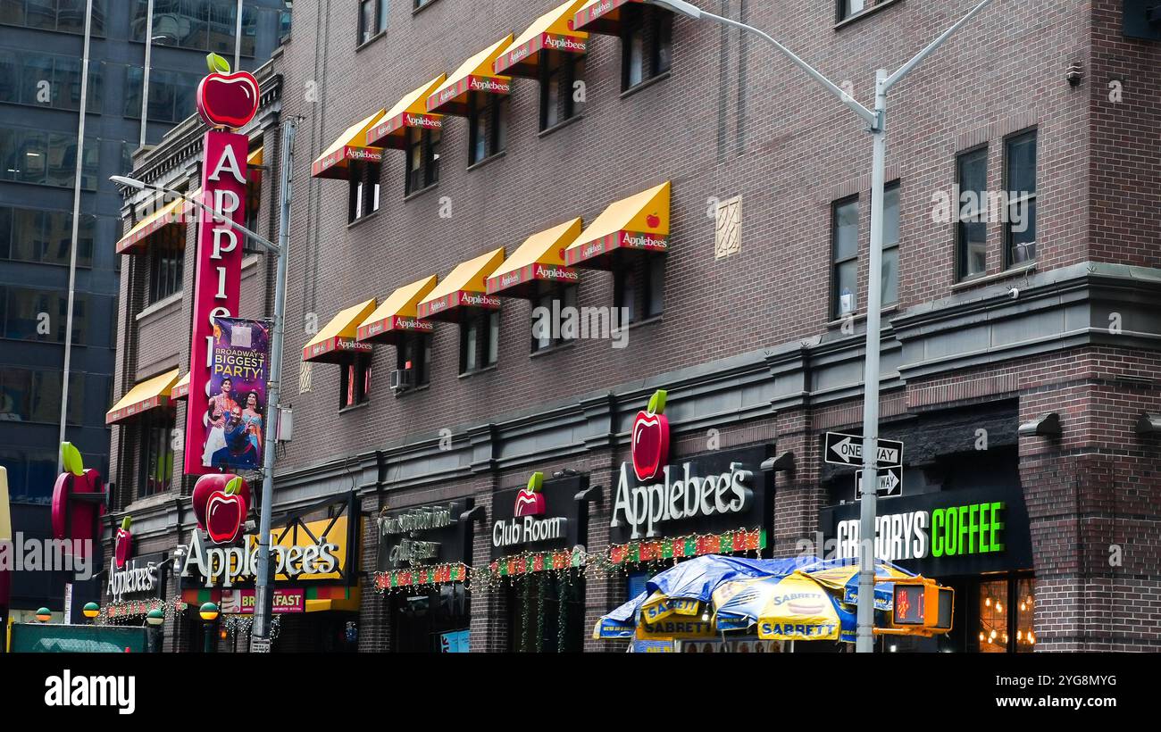 NEW YORK, NY États-Unis - 10 JANVIER 2024 : un restaurant Applebee's avec des auvents jaunes et un grand logo de pomme rouge est visible au milieu d'une rue de la ville Banque D'Images