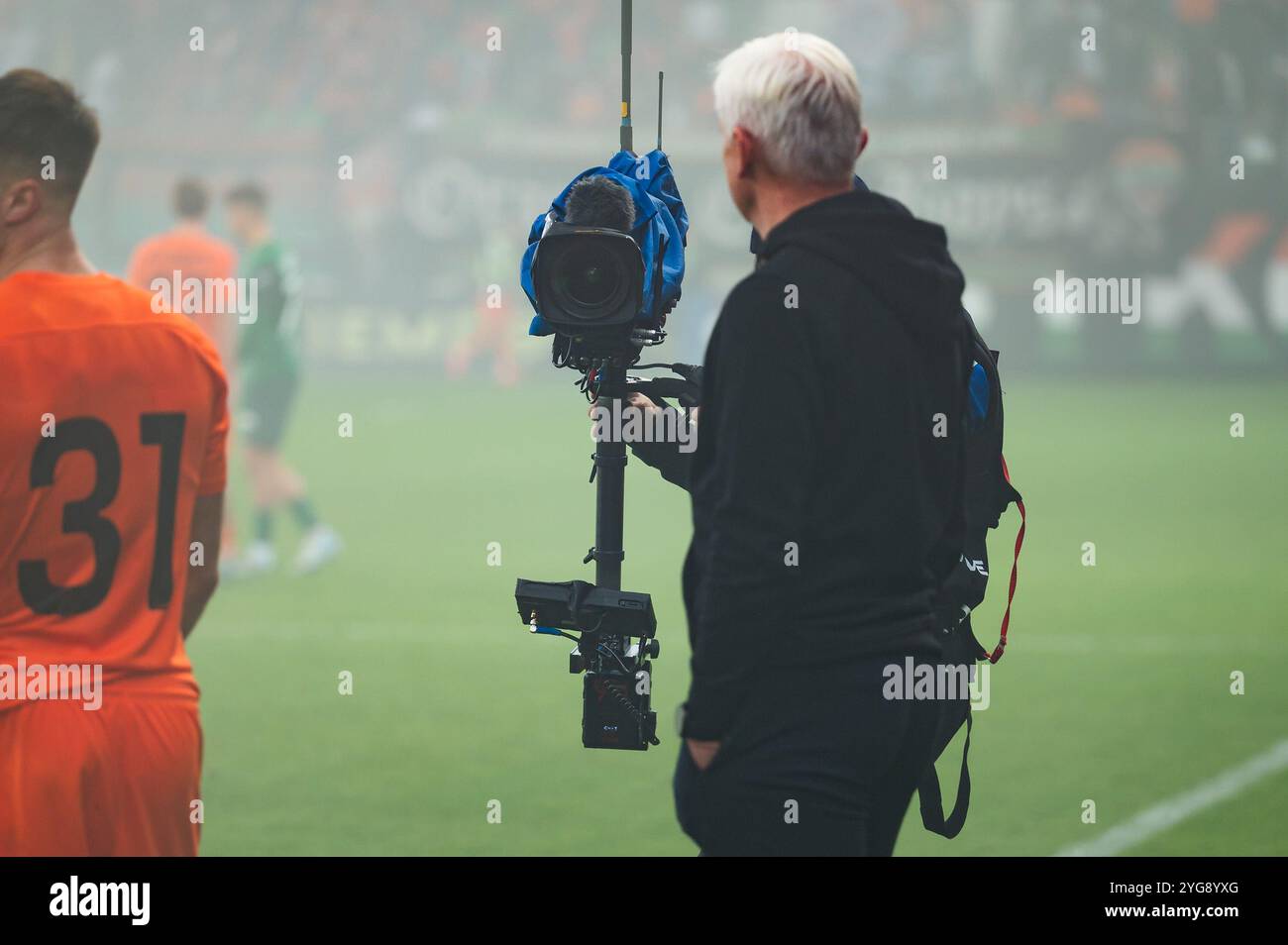 Caméra TV regardant sur l'entraîneur derrière le terrain de jeu pendant le match de football. Banque D'Images