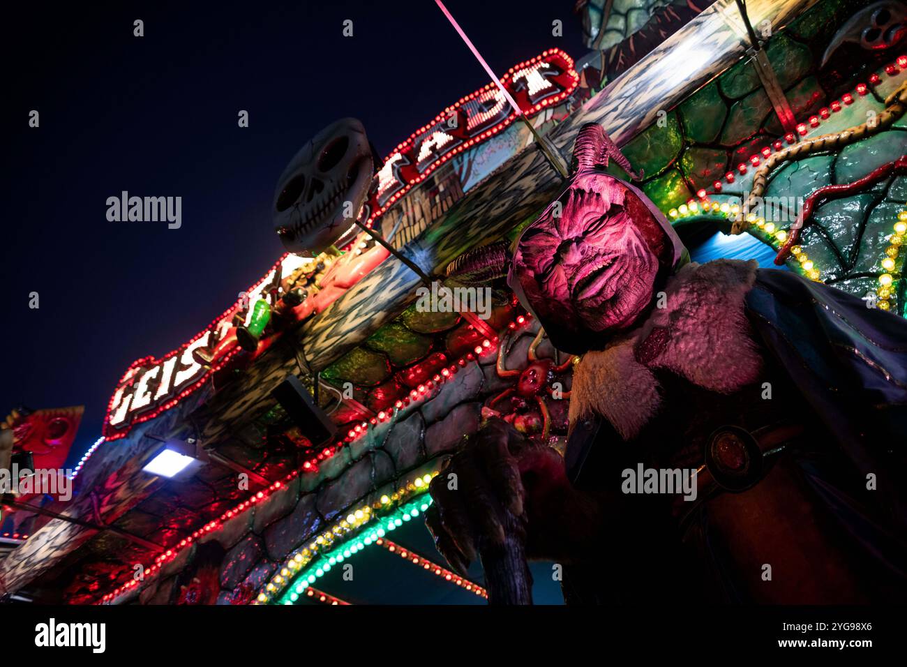 Soest, Allemagne. 06 novembre 2024. Une figure effrayante se tient devant un train fantôme à la Foire de tous les Saints. Selon les organisateurs, le festival traditionnel est la plus grande foire funiculaire du centre-ville en Europe. Environ un million de visiteurs sont attendus à la foire au milieu de la vieille ville historique de Soest jusqu'à dimanche. Crédit : Fabian Strauch/dpa/Alamy Live News Banque D'Images