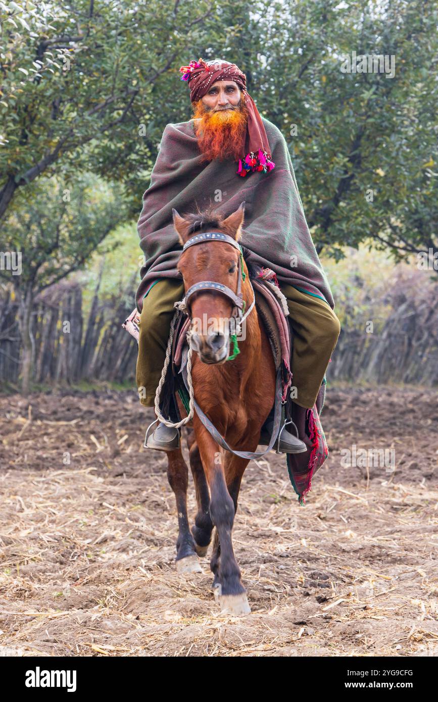 Khan Sahib Tehsil, Jammu-et-Cachemire, Inde. Homme avec une barbe teinte au henné rouge à cheval. Banque D'Images