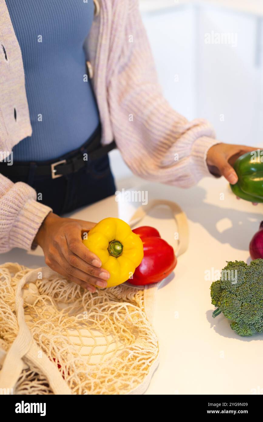 Préparer un repas sain, trier les poivrons colorés et le brocoli au comptoir de la cuisine, à la maison Banque D'Images