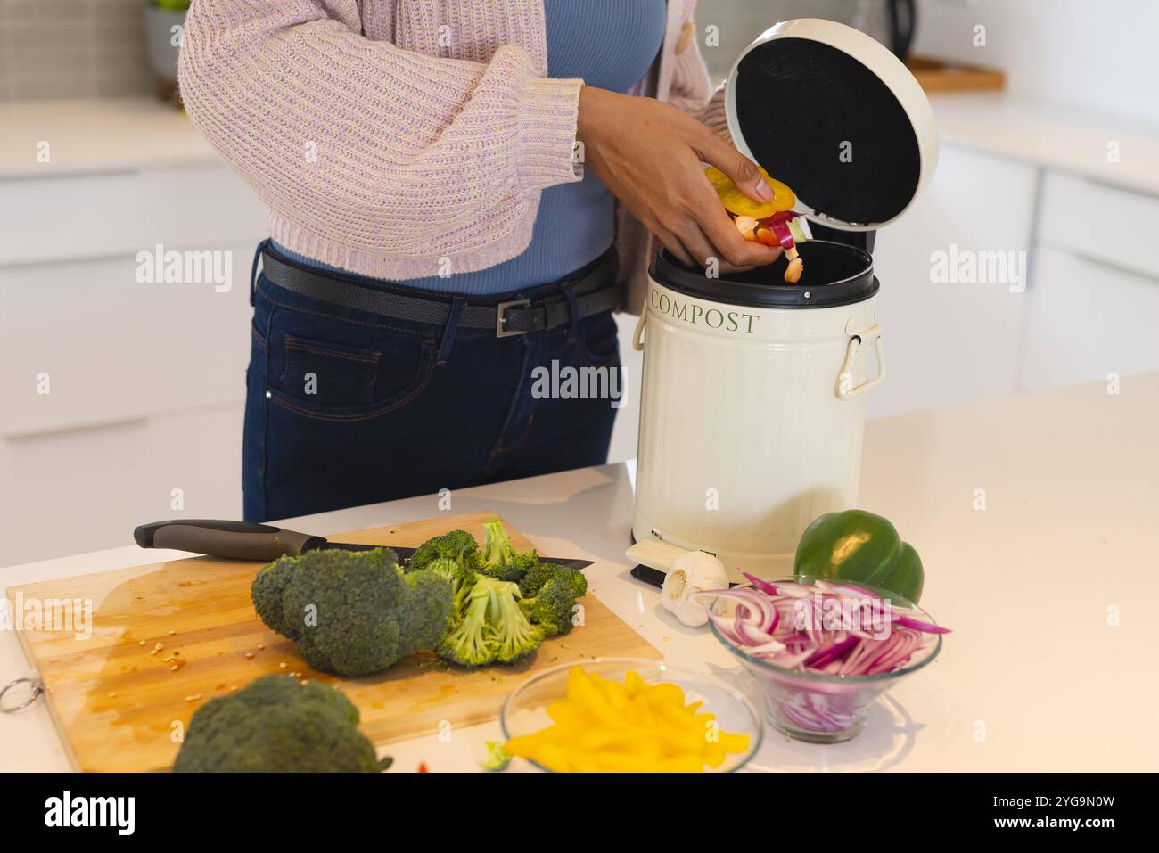 Compostage des déchets de légumes dans la cuisine, femme promouvant un mode de vie écologique, à la maison Banque D'Images