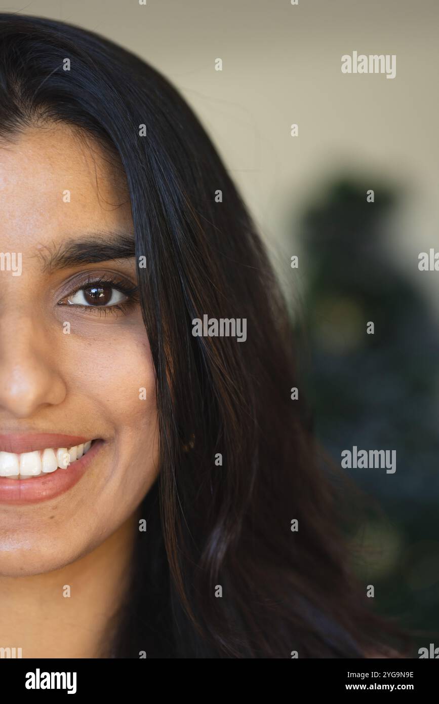 Femme souriante avec de longs cheveux profitant d'une atmosphère de vacances festive à la maison, espace de copie Banque D'Images