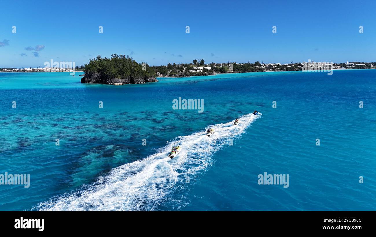 Un tir dynamique par drone capture des jet-skis de course qui traversent les superbes eaux des Bermudes, créant des éclaboussures et des sentiers dans la mer Banque D'Images