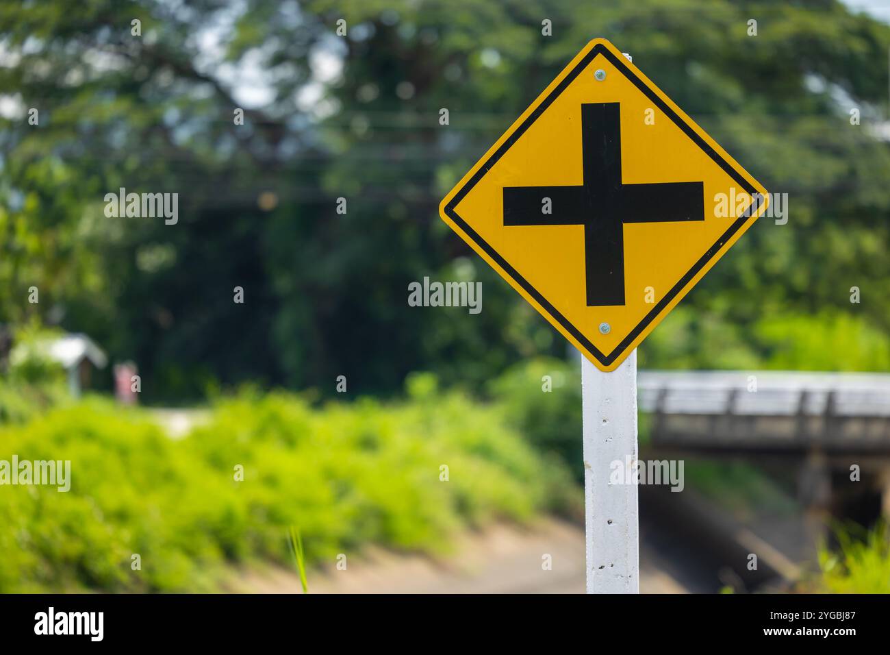 Panneau de signalisation jaune à l'intersection, avertissement quatre carrefours devant vous, badge de signalisation routière attention à une voiture à vitesse lente à l'intersection. Banque D'Images