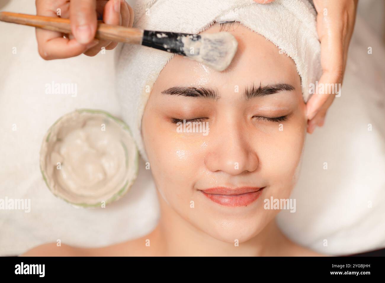 Esthéticienne appliquer la crème à base de plantes faciales et massage des mains dans le spa, soin du visage soin du corps Relax Claim avec soin de la peau bébé visage au bien-être. Banque D'Images