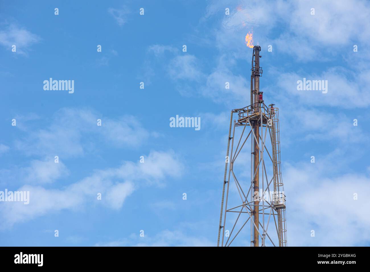 Plate-forme de tour de torchage de cheminée à torche élevée à foyer de gaz méthane dans une usine pétrolière de raffinerie ou brûlage de flamme sur un procédé d'extraction de pétrole offshore. Banque D'Images