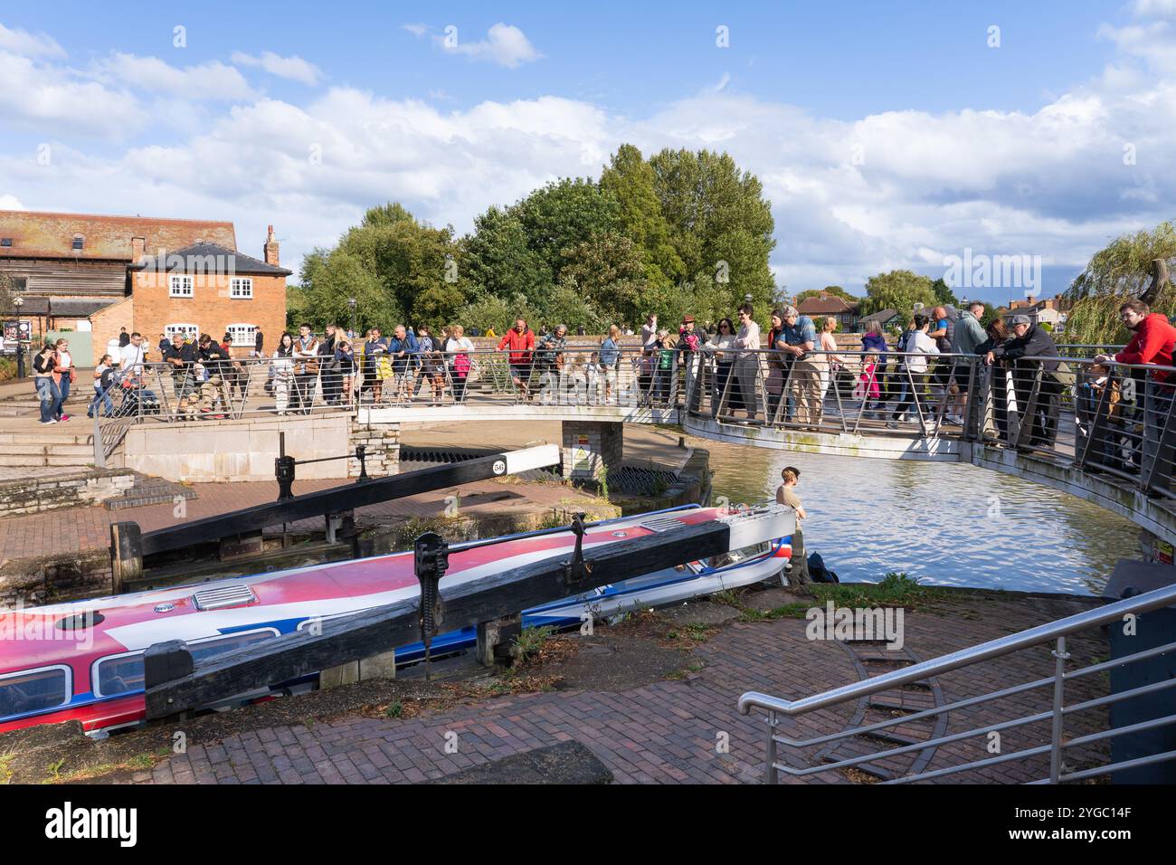 Bateau d'excursion Jennifer May passant à travers le canal de Stratford dans la rivière Avon, surveillé par les touristes un jour d'été, Stratford upon Avon, Angleterre Banque D'Images